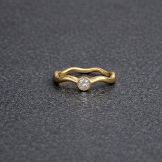 Gold wavy ring with a small diamond