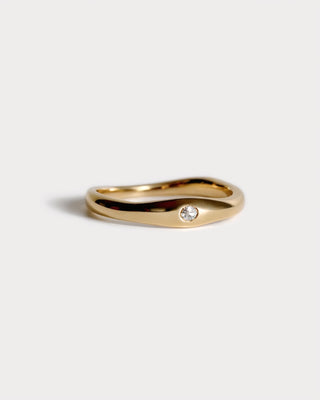 Gold sculptural wedding ring with small diamond